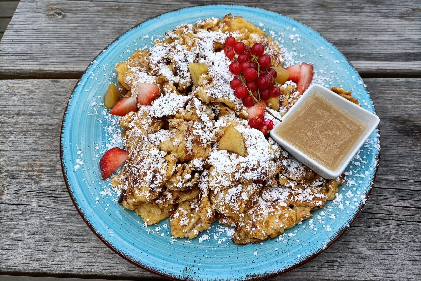Kaiserschmarrn mit Puderzucker, frischen Beeren und Apfelmus
