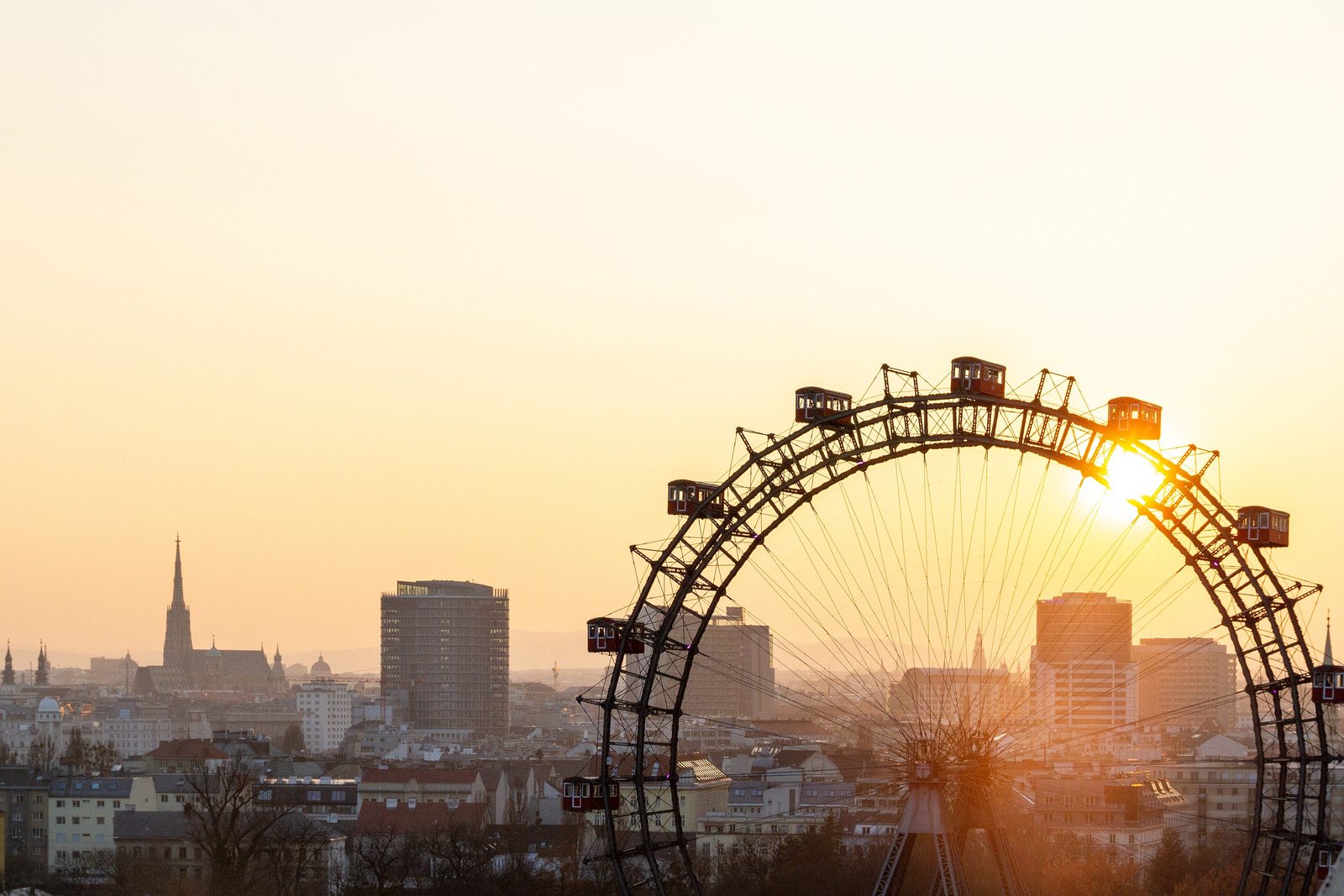 Das Wiener Riesenrad im Prater vor der Wiener Skyline im Abendlicht
