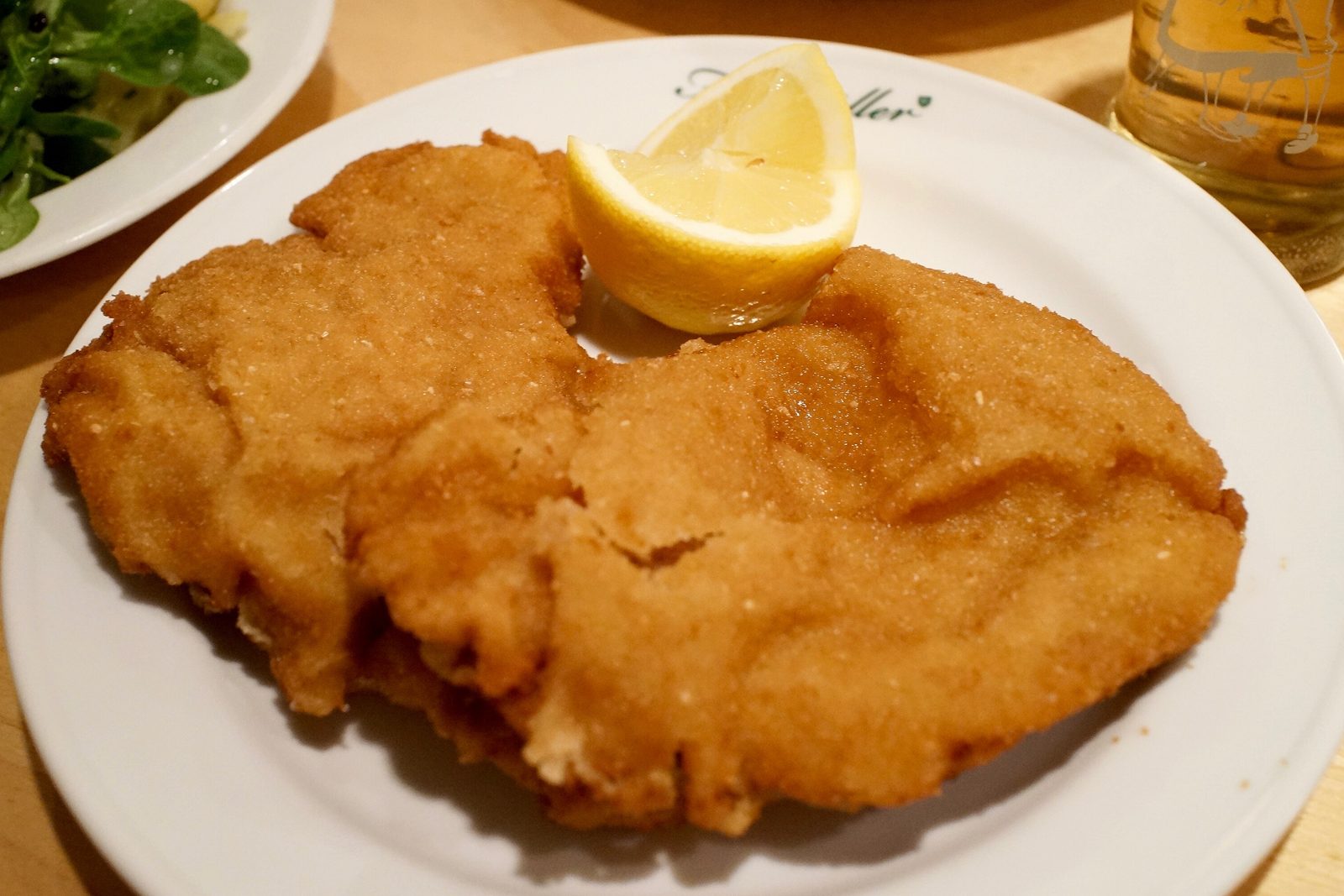 Goldbraun souffliertes Wiener Schnitzel mit Zitrone beim Figlmüller